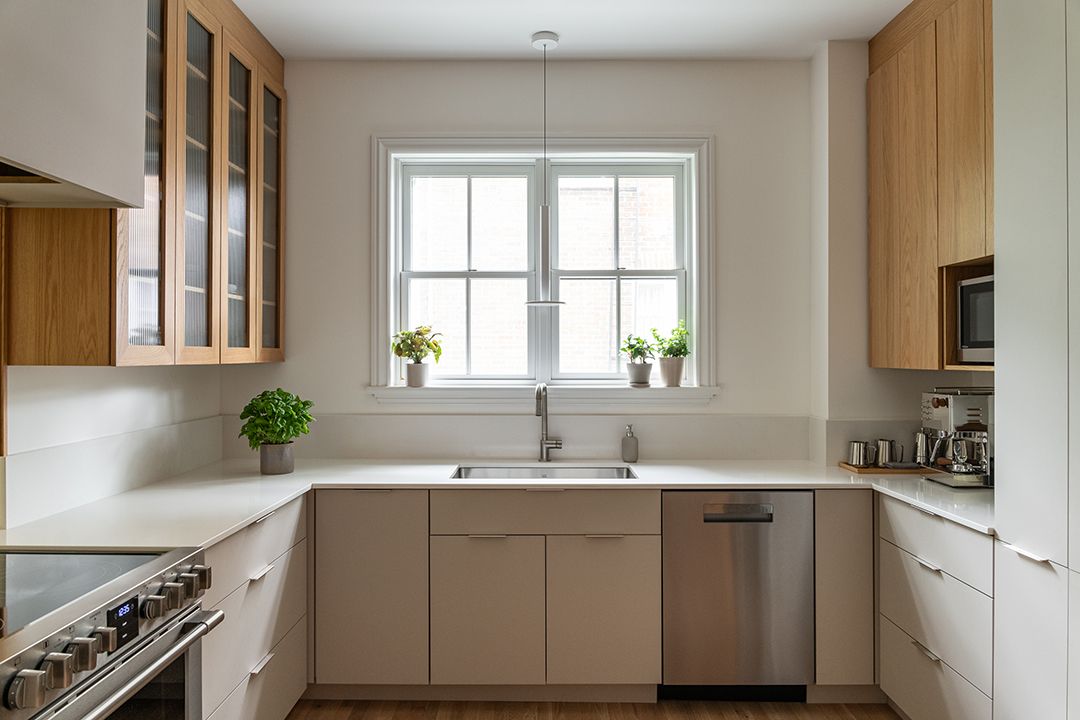 Une cuisine avec évier , cuisinière , lave - vaisselle et fenêtre.