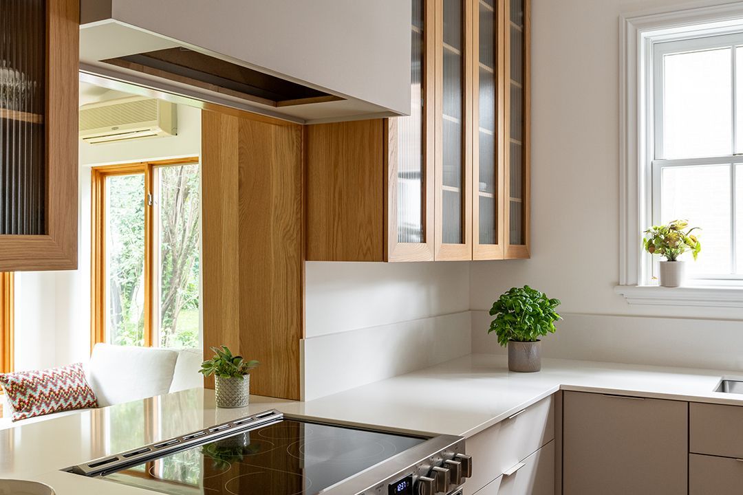 Une cuisine avec une cuisinière et une fenêtre.