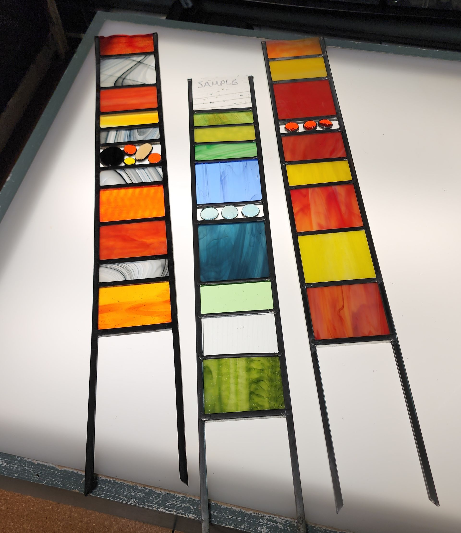 Brightly colored stained glass garden stakes. Workshop available at hen Picked Antiques & Stained Glass. 