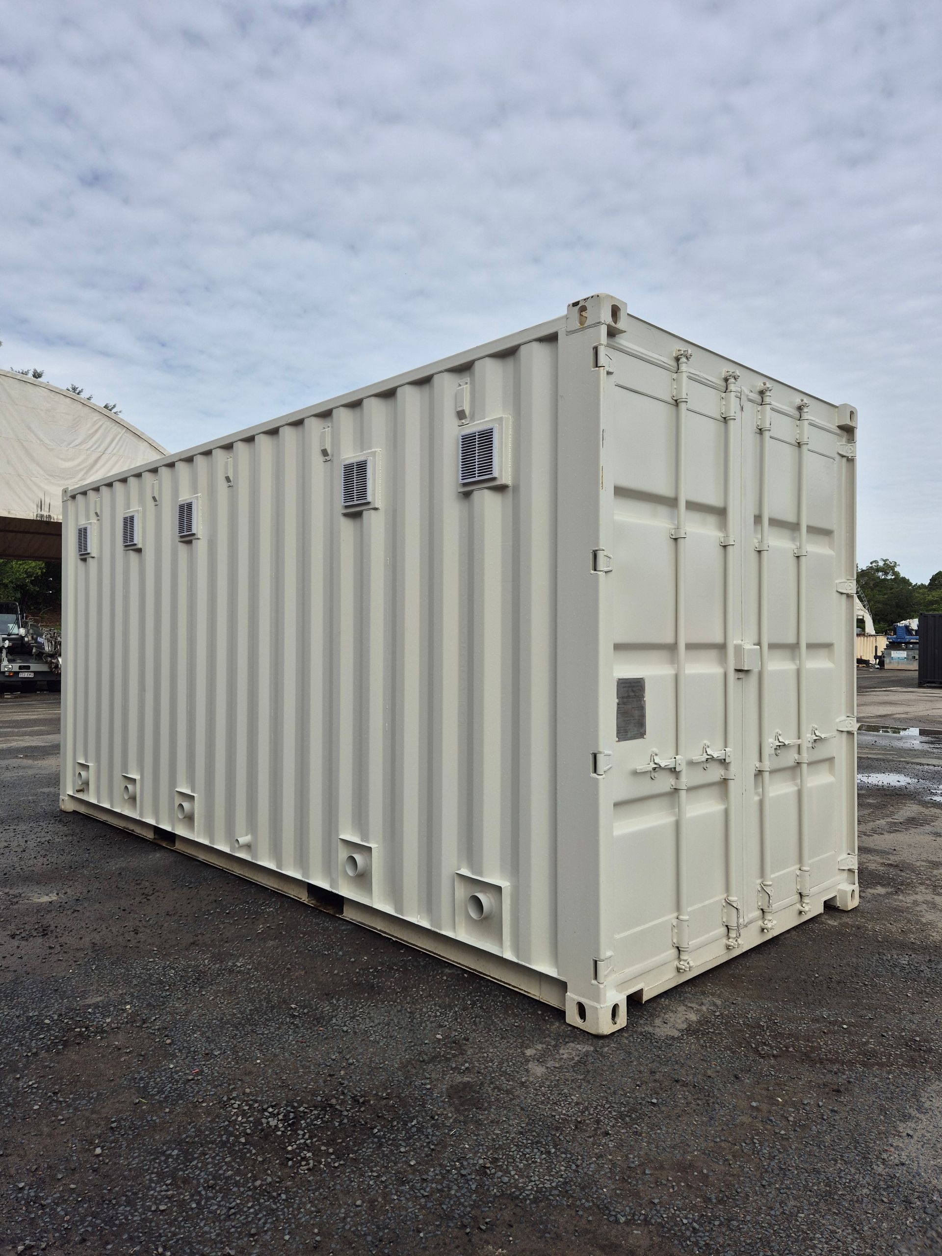 A White Shipping Container Stands on a Gravel on the East Coast