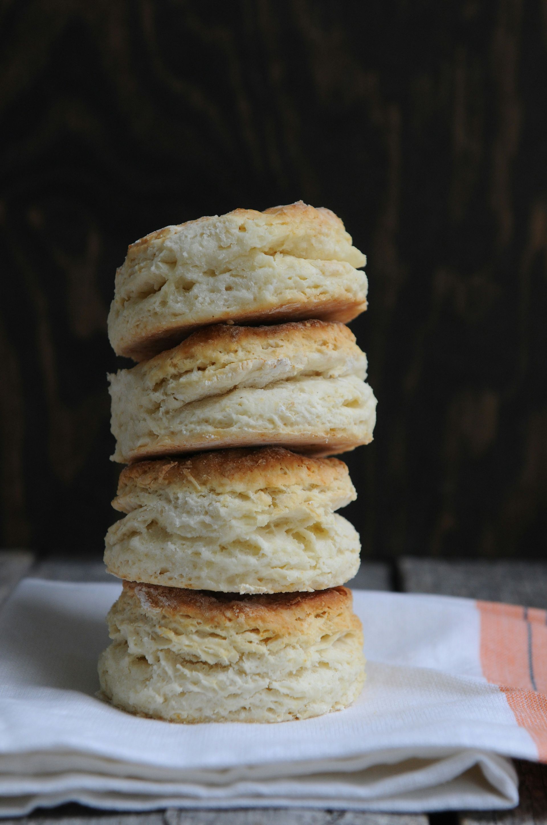 Four biscuits are stacked on top of each other on a napkin.