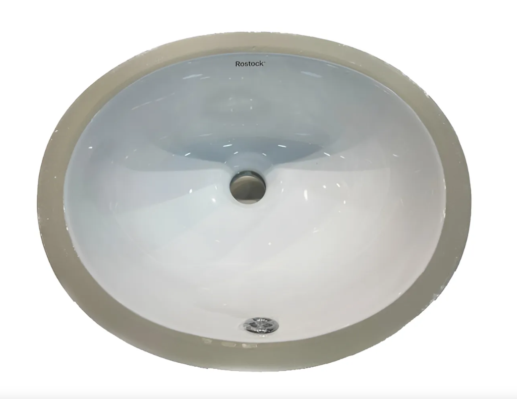 Lavabo de baño ovalado de color blanco y borde gris.