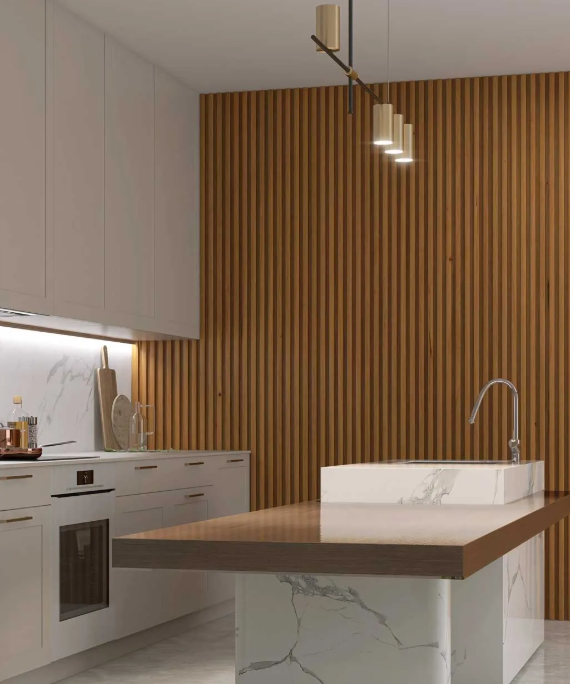 Cocina moderna con isla de mármol, pared decorativa de madera y luces colgantes.