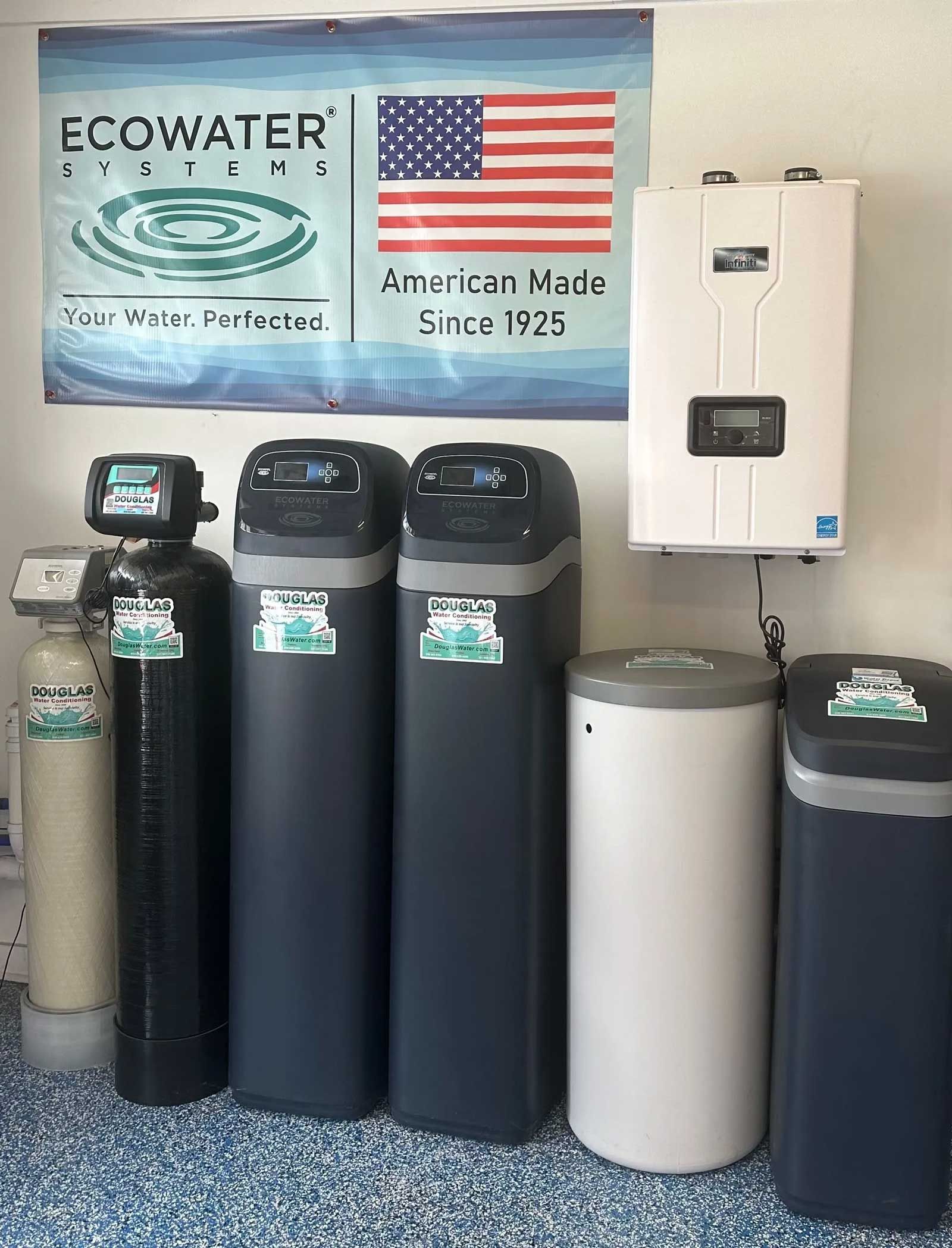 Water treatment systems, including softeners, in a showroom, with an American flag in the background.