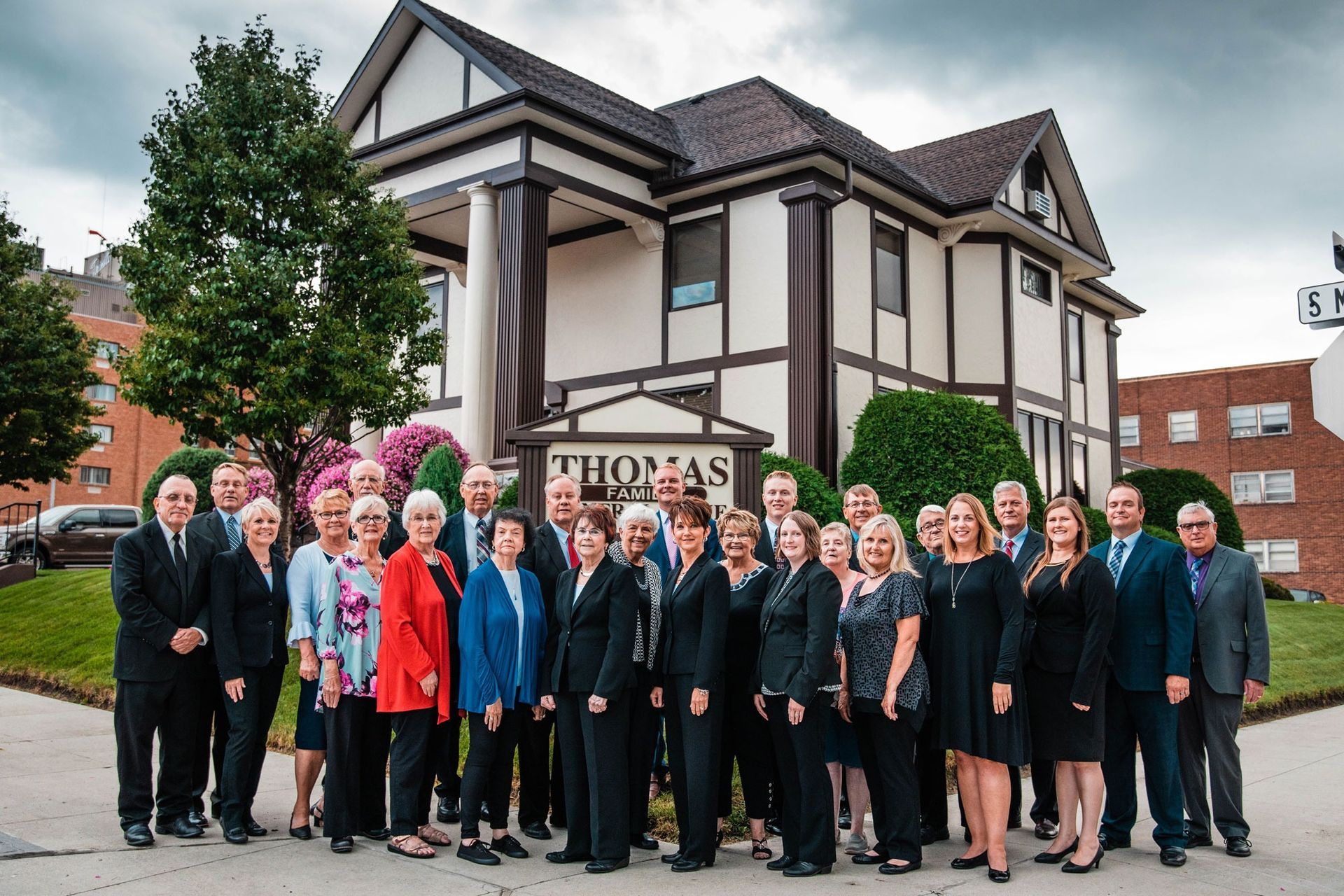The front door of a house with a porch and plants in front of it.