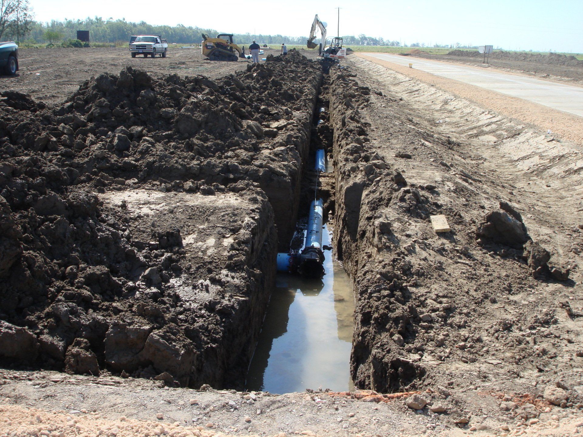 A large hole in the ground with a blue pipe in it