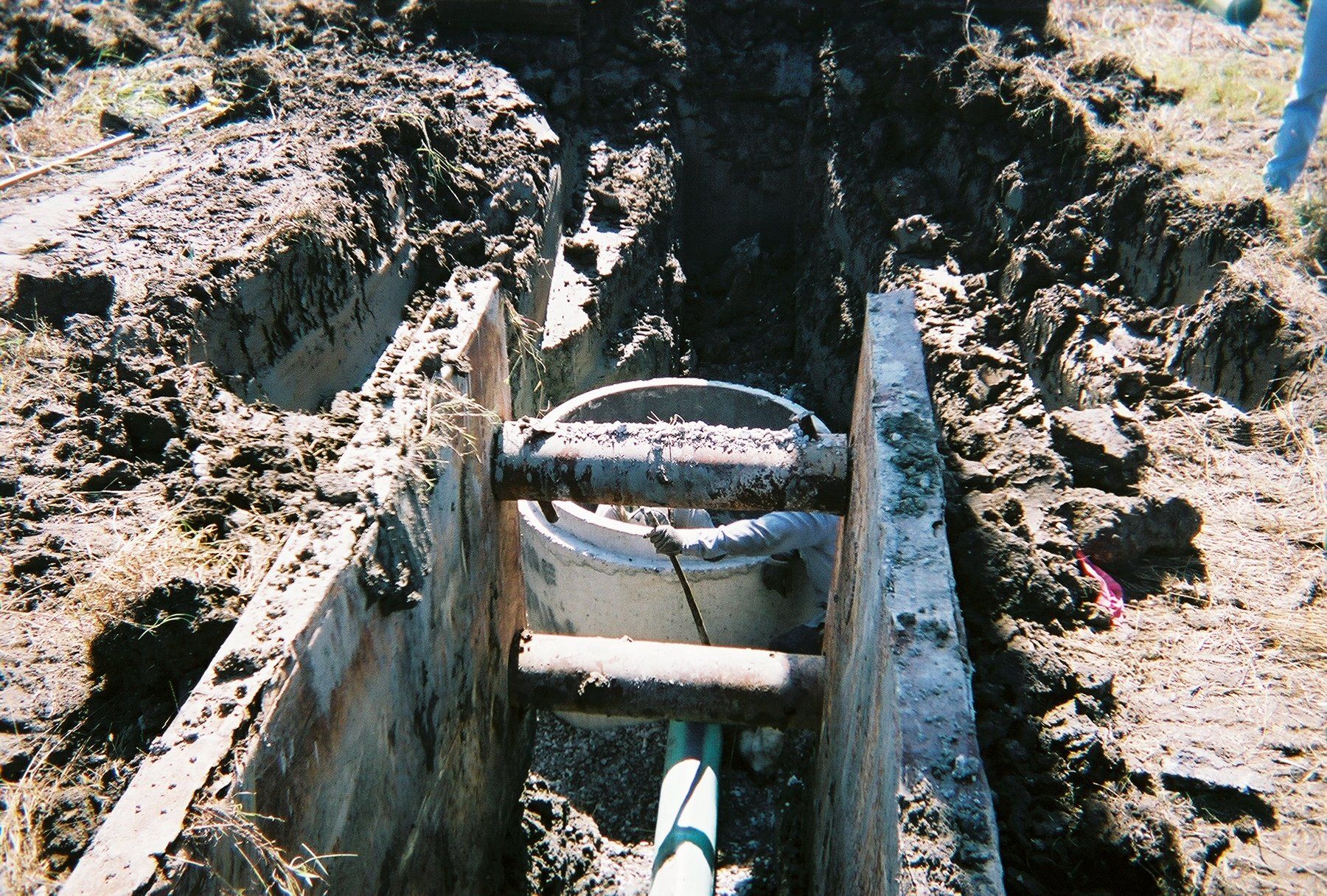 A hole in the ground with a pipe in it