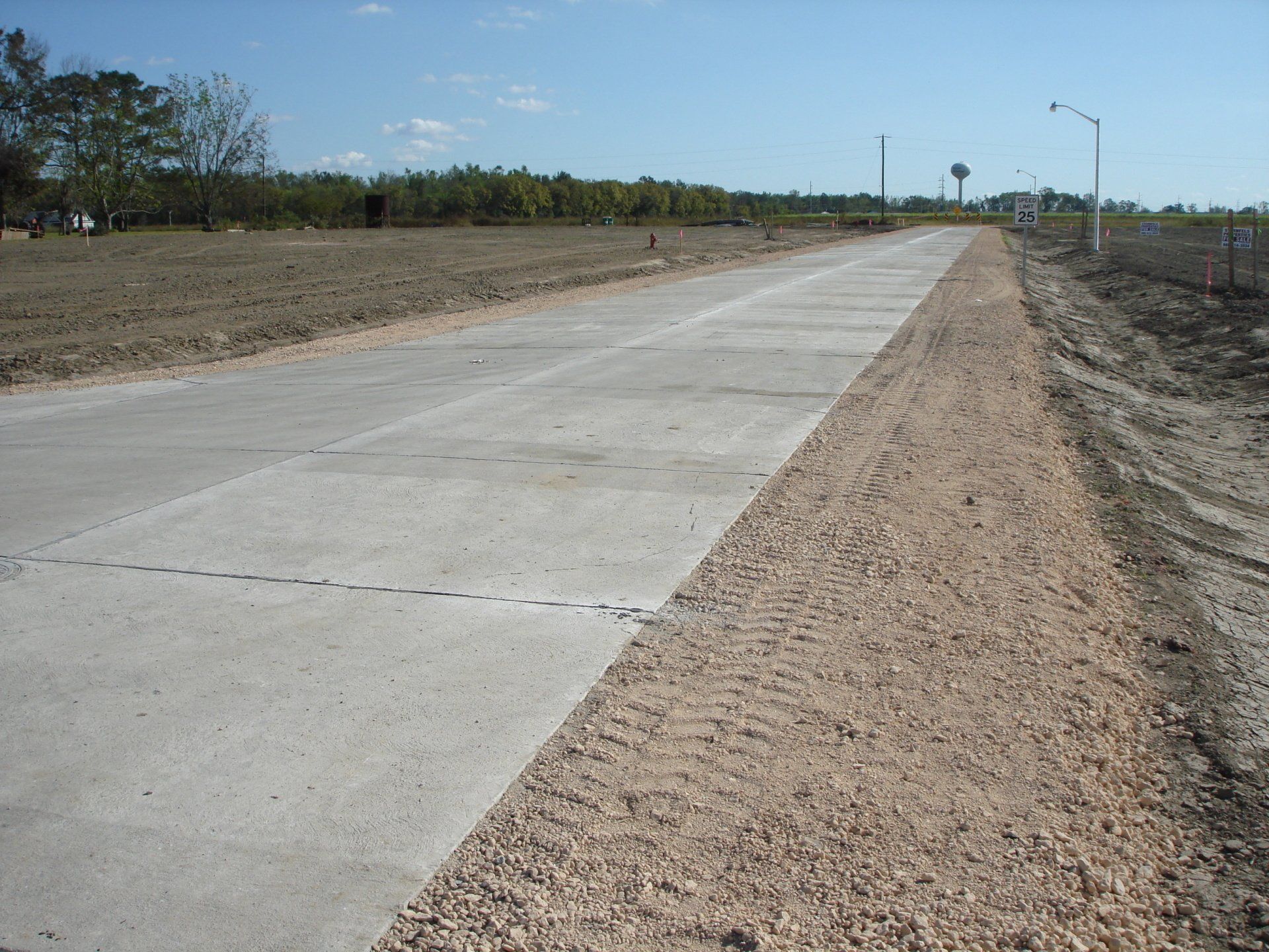 A concrete road with gravel on the side of it