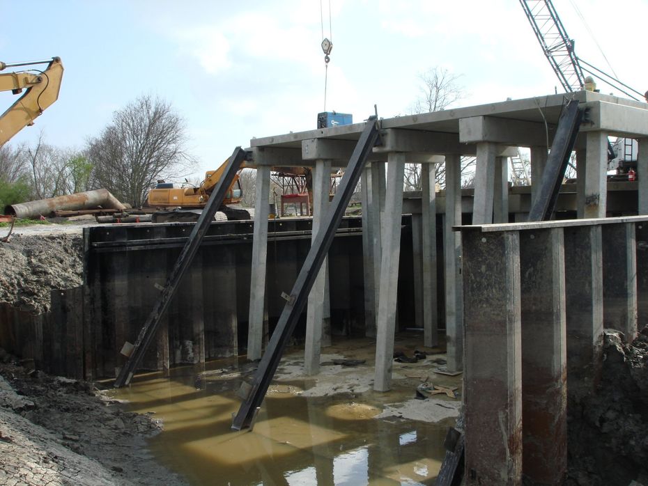 A crane is lifting a concrete structure over a body of water