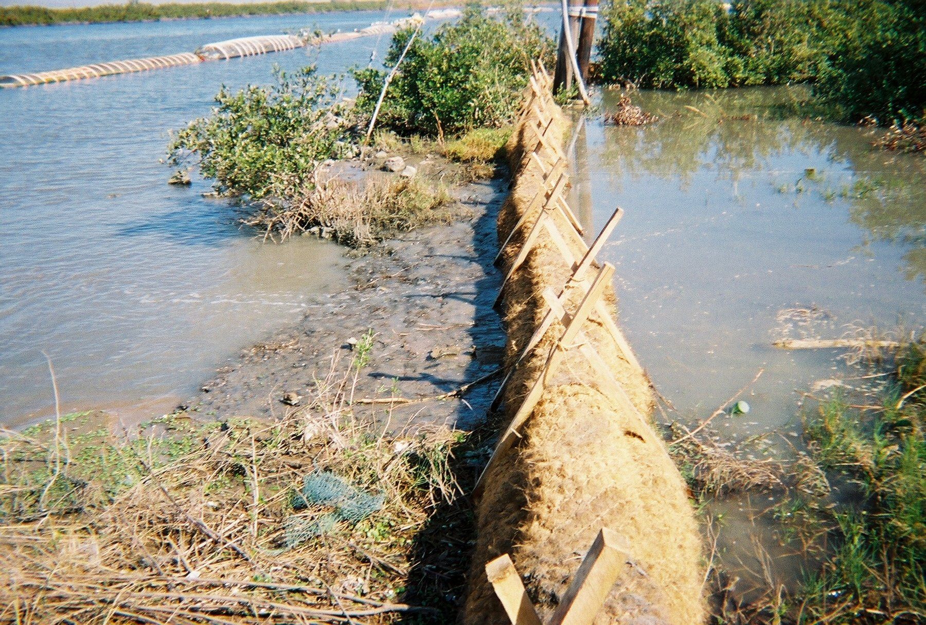 A large body of water with a fence in the foreground