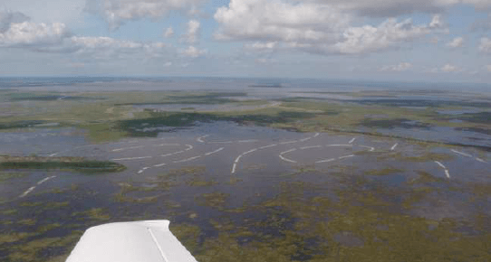 A plane is flying over a large body of water.