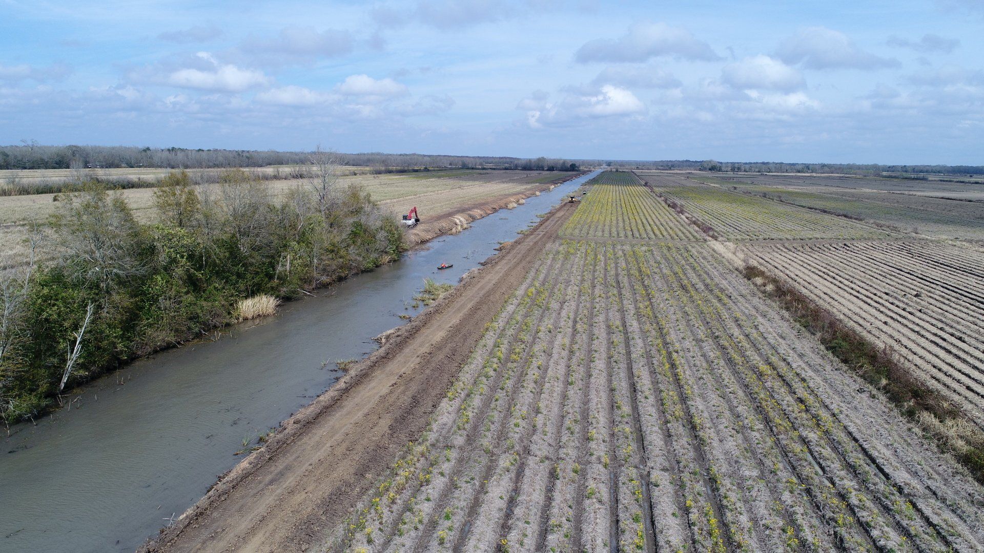 An aerial view of a river running through a lush green field.