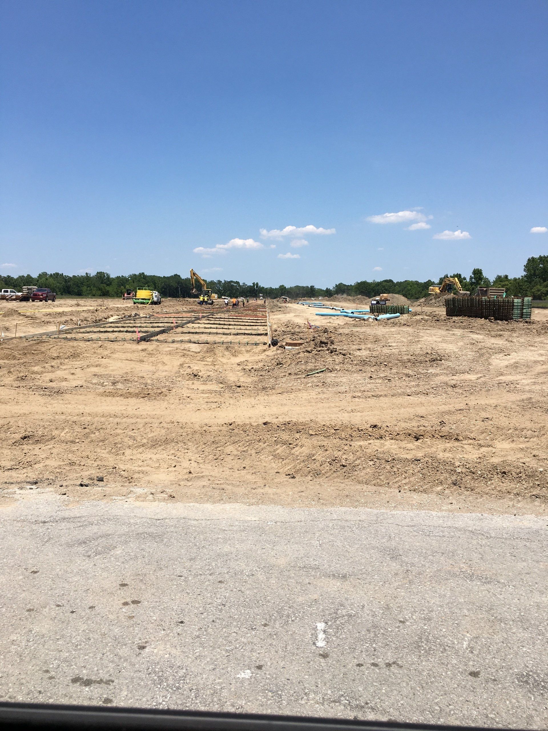 A large dirt field with a blue sky in the background