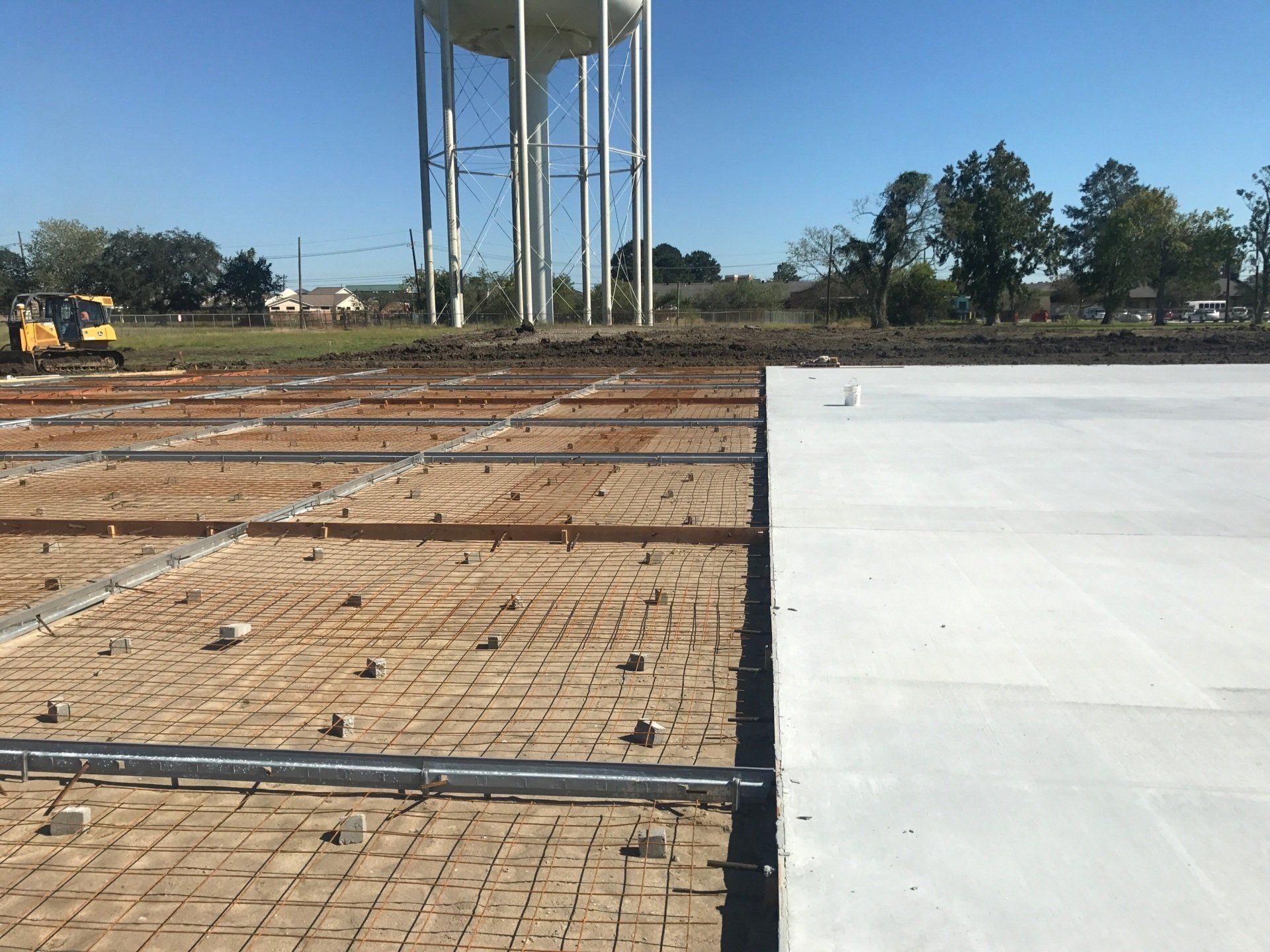 A construction site with a water tower in the background.