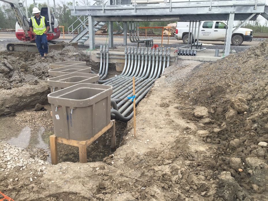 A construction site with a lot of pipes in the dirt