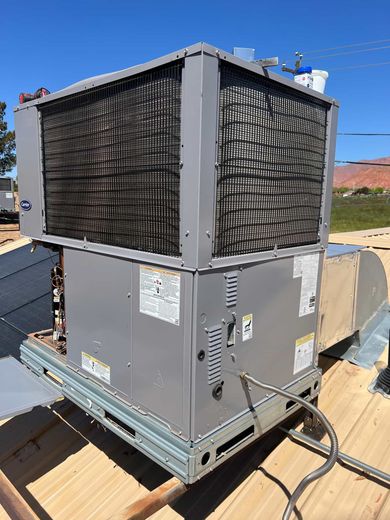 A large air conditioner is sitting on top of a wooden roof.