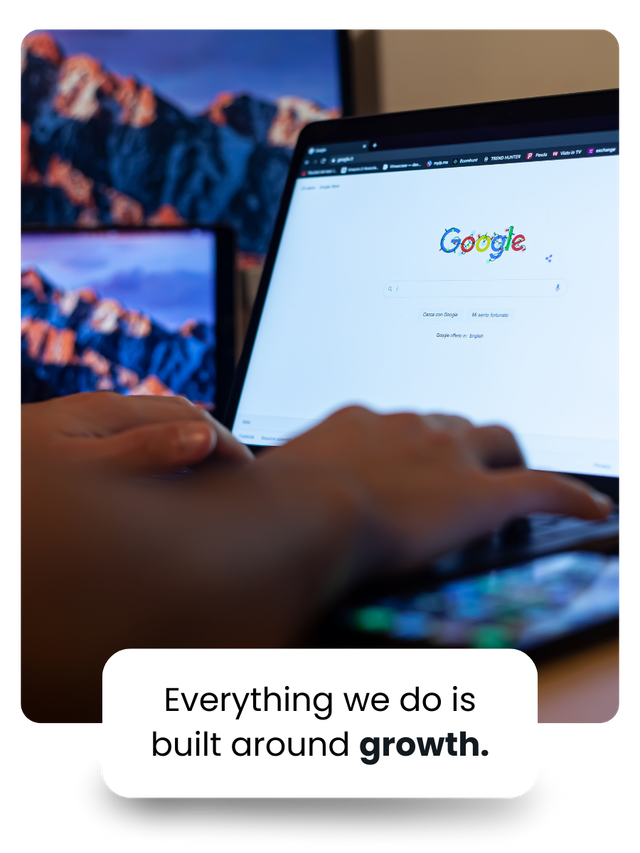 Person typing on laptop with Google search open, with mountain screens visible.