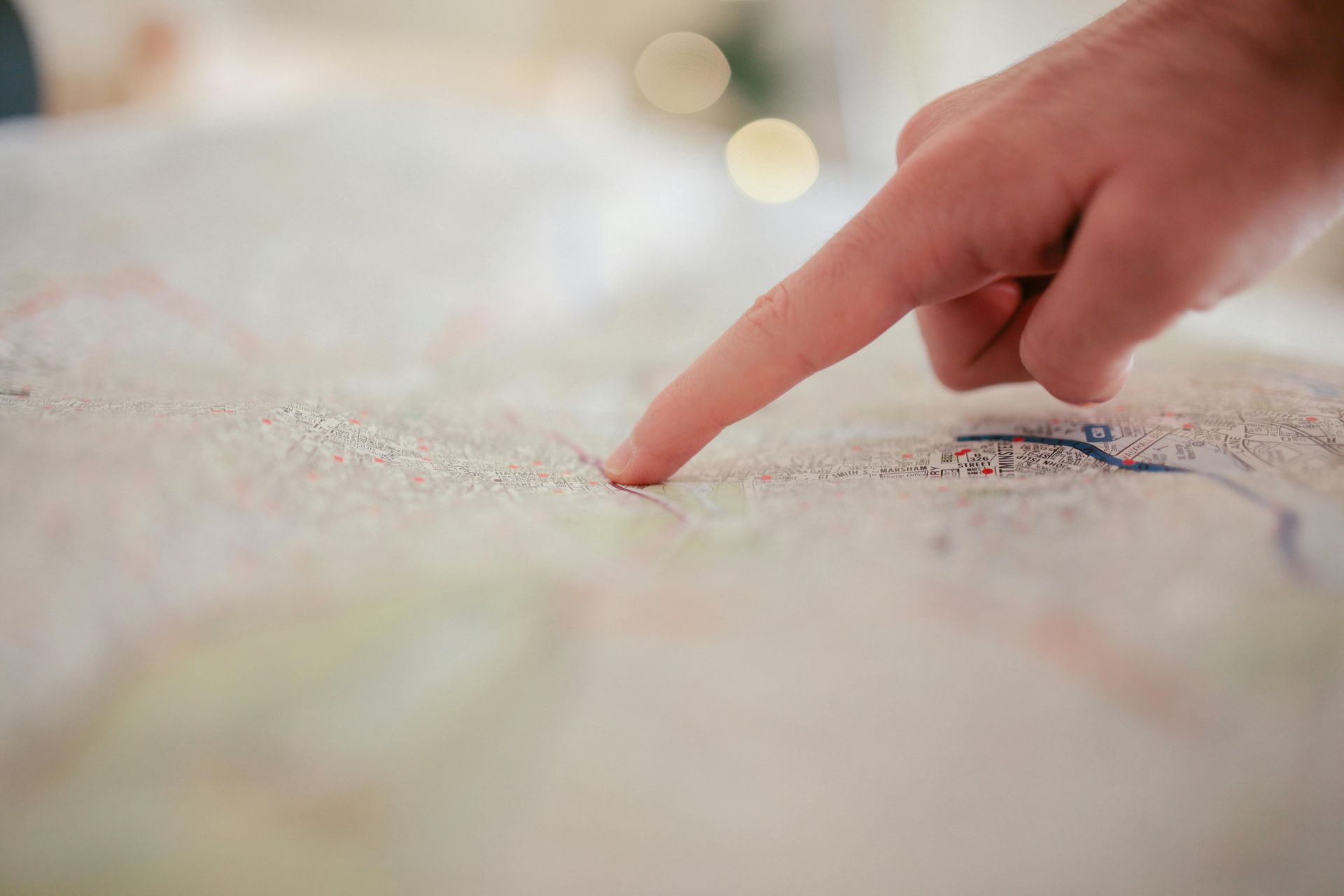 Hand pointing to a map, possibly planning a route or location.
