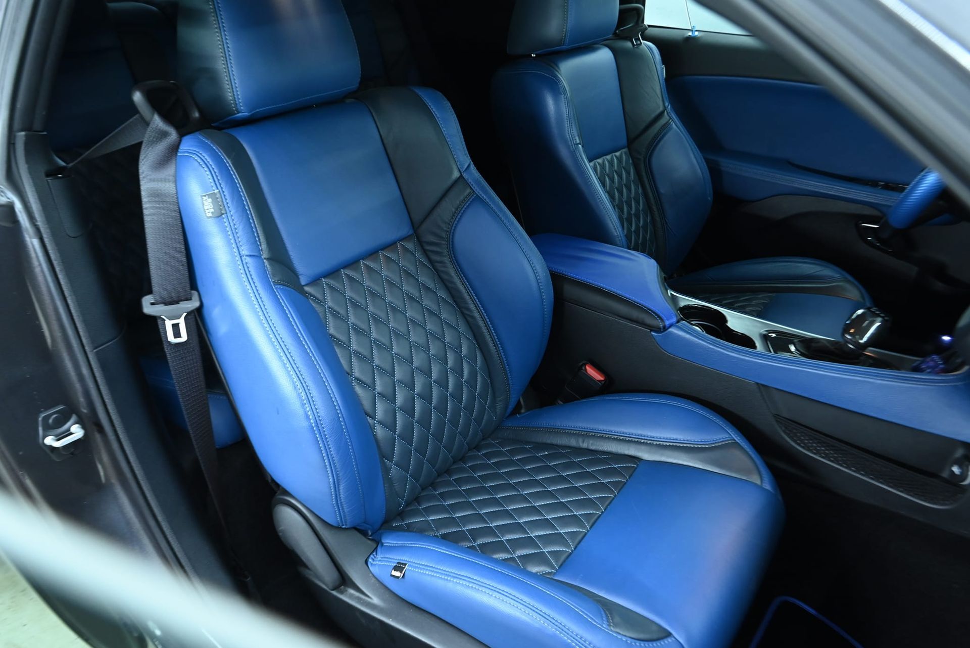 Blue and black leather car seats with diamond stitching.