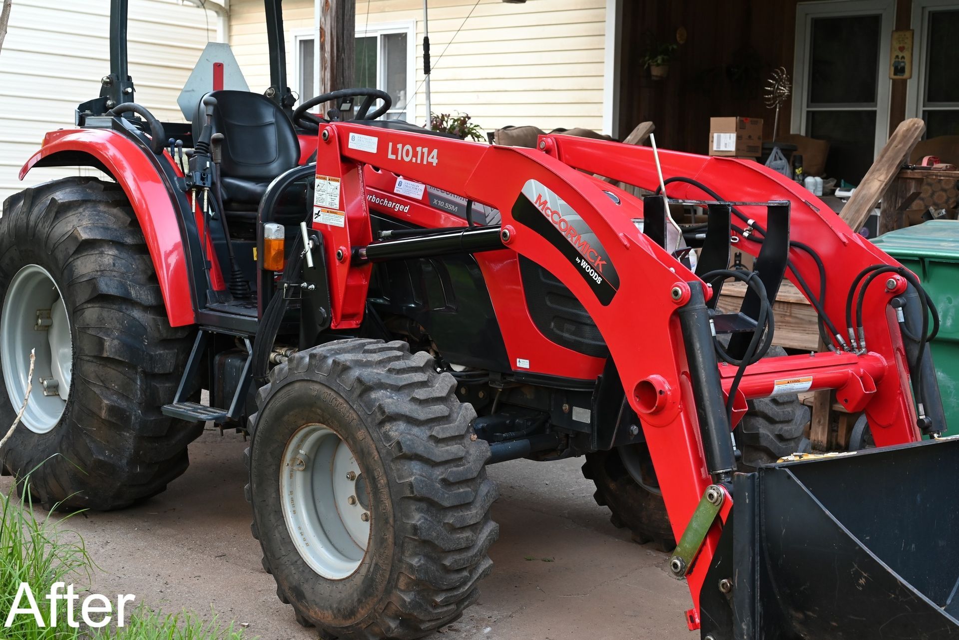 Red tractor with front loader parked outdoors.