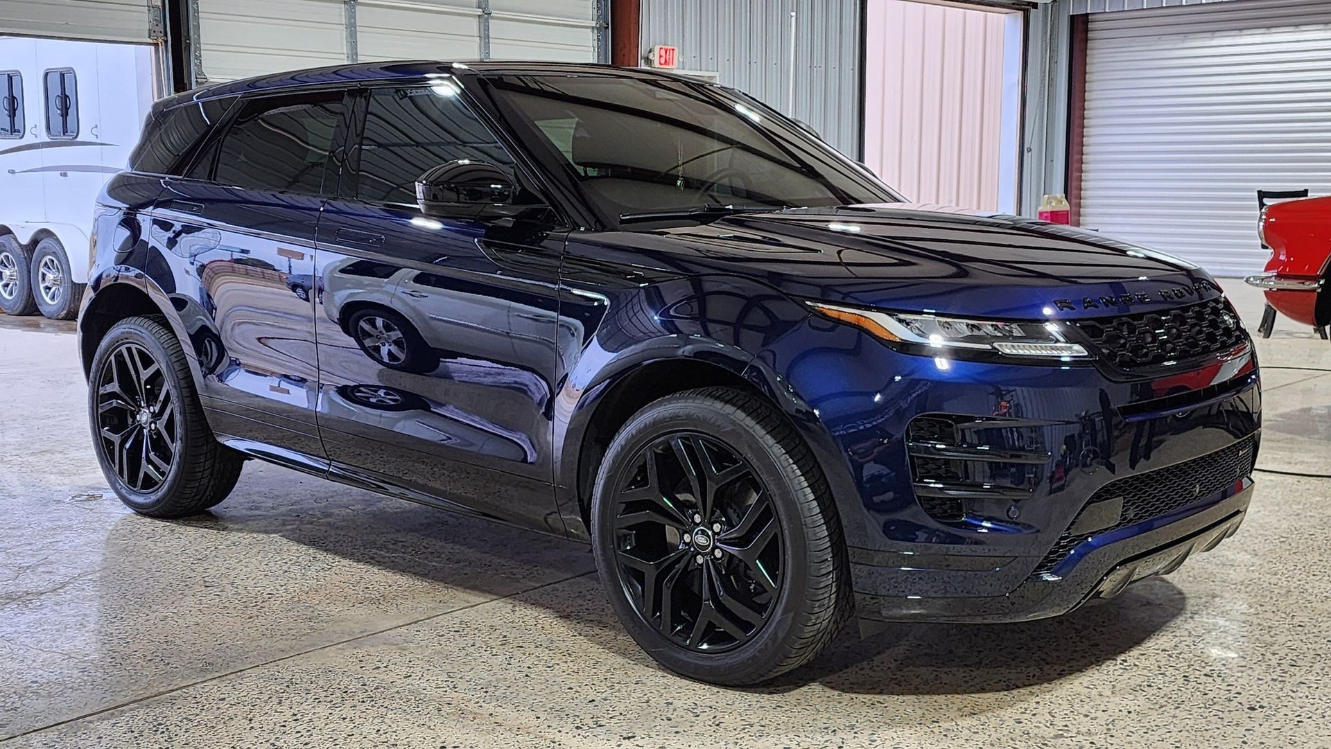 Dark blue SUV with black rims parked inside a building.