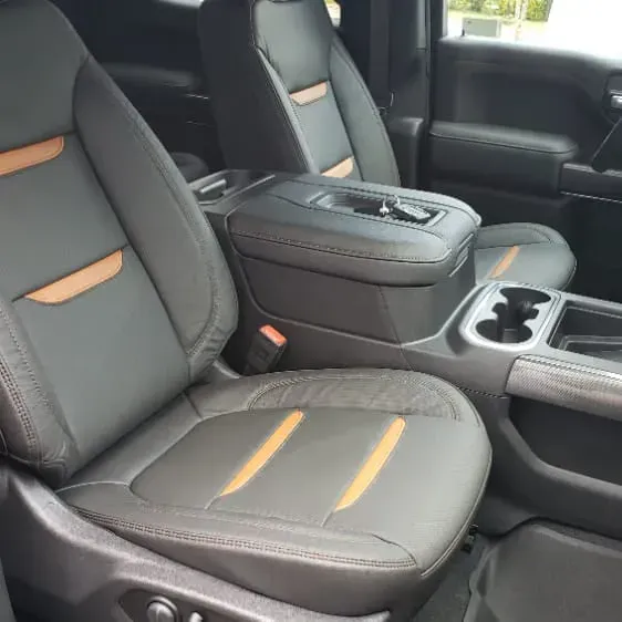 Black leather truck interior with tan accents; center console with cup holders.