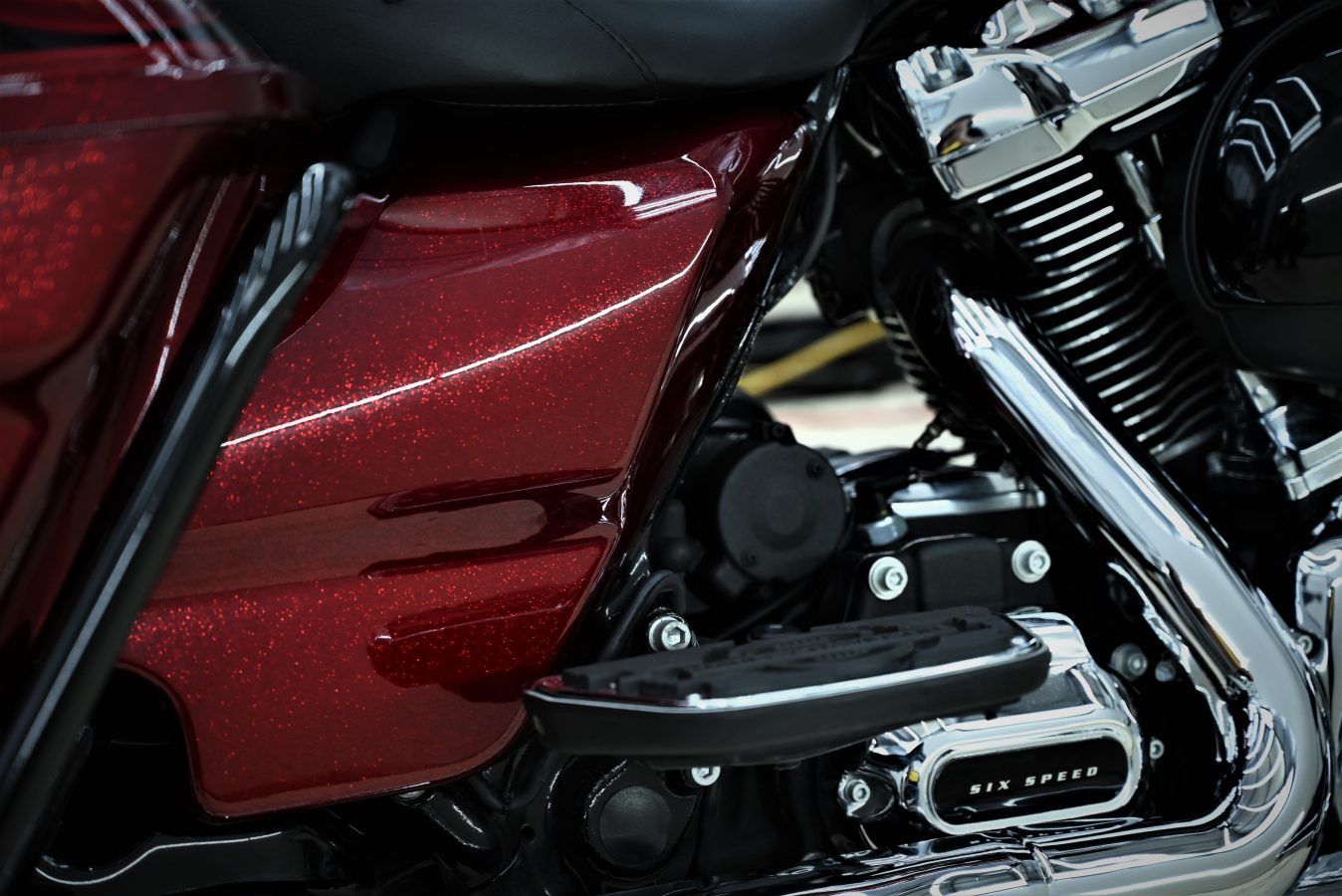 Red motorcycle side panel with engine and chrome components.