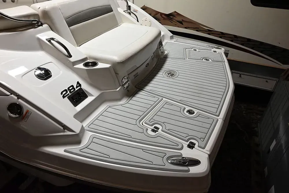 White boat with gray deck and cushioned seat. Boat model 284 is visible.