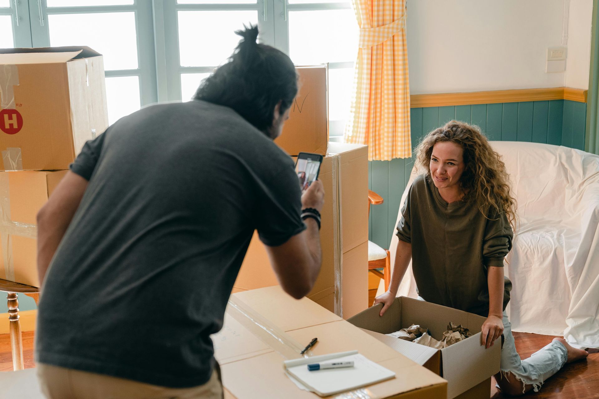 Two tenants packing up boxes while preparing to move out of their rental unit.