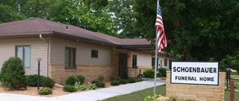 A funeral home with an american flag in front of it.