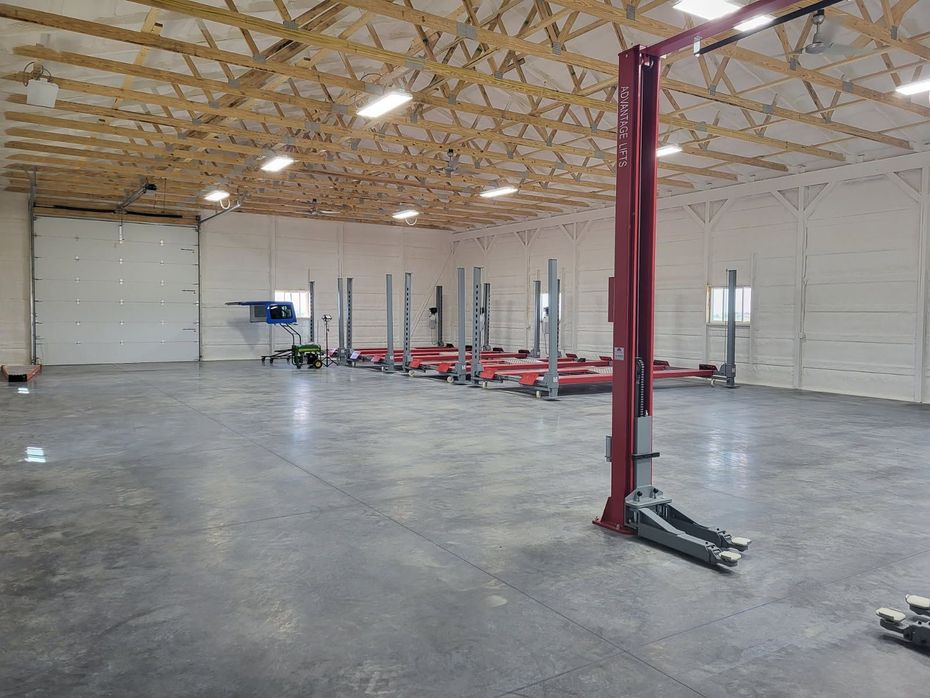 A large empty garage with a lot of lifts in it.
