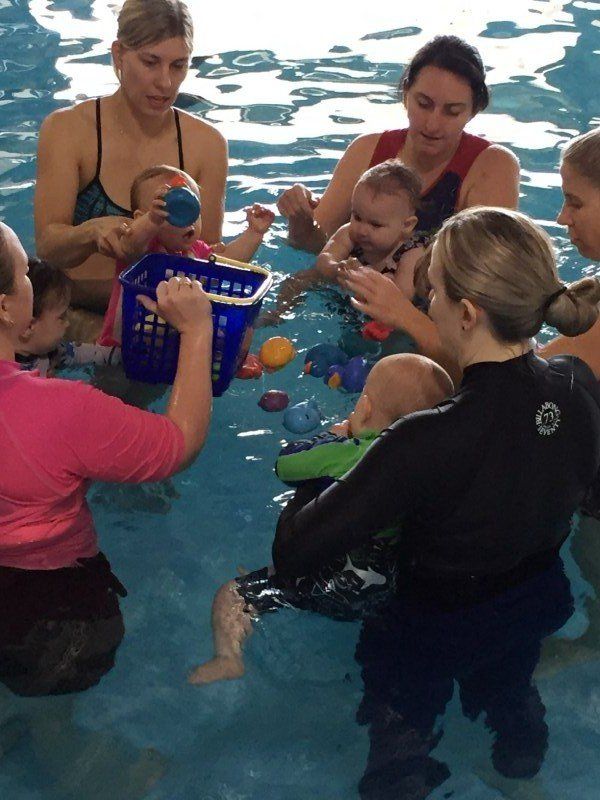 Young women playing with their kids in water