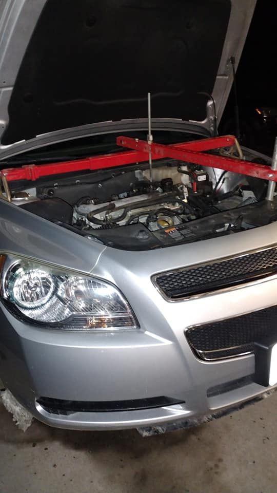 Silver car with hood open, red engine support beam in place. | Zoom Automotive