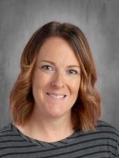A woman in a striped shirt is smiling for the camera.
