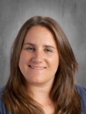 A woman with long brown hair is smiling for the camera.