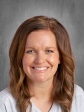 A woman with long brown hair is smiling for the camera.