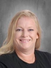 A woman with blonde hair is smiling and wearing a black shirt.