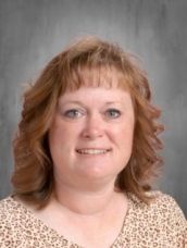 A woman in a leopard print shirt is smiling for the camera.