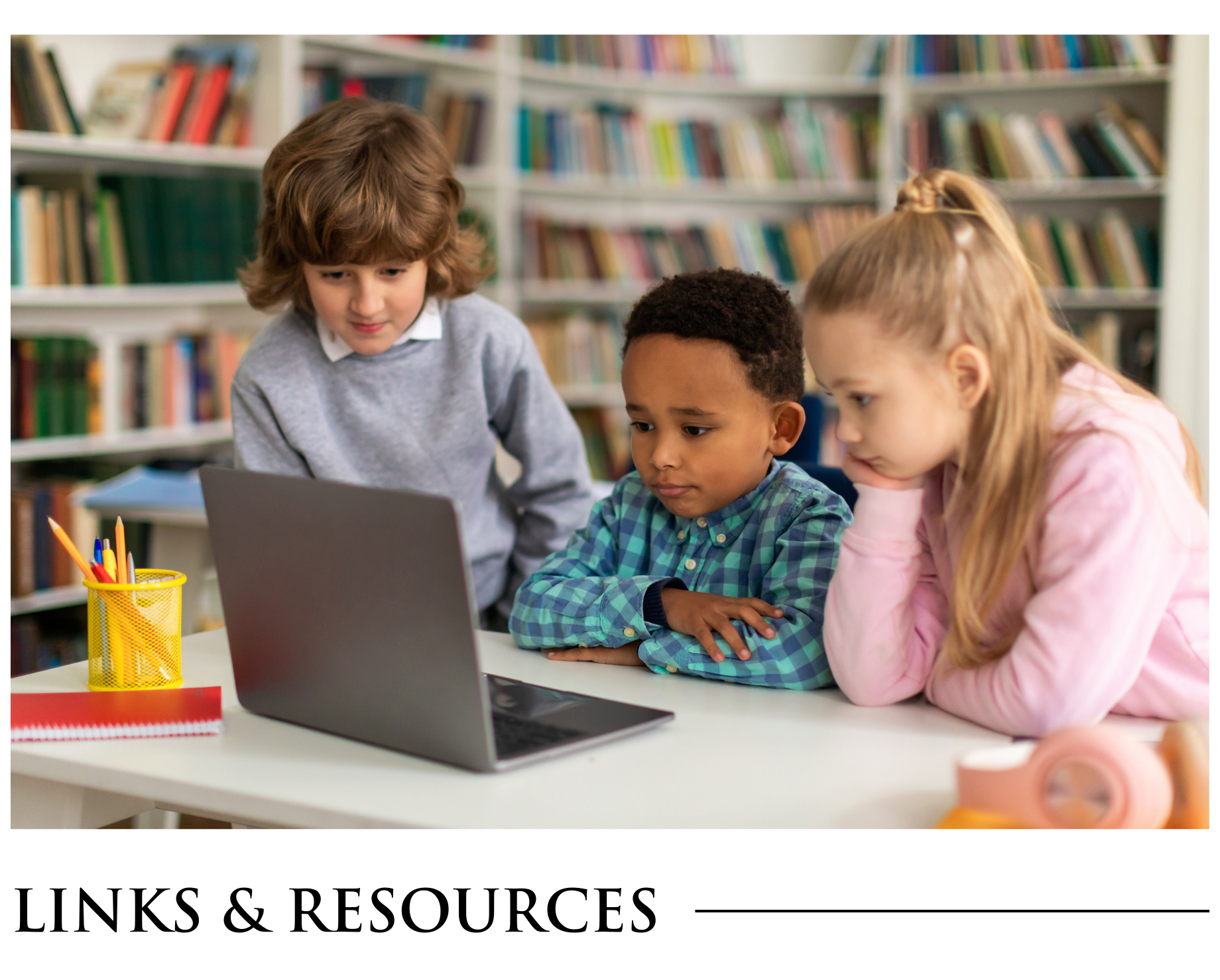 A group of children are sitting at a table looking at a laptop computer.