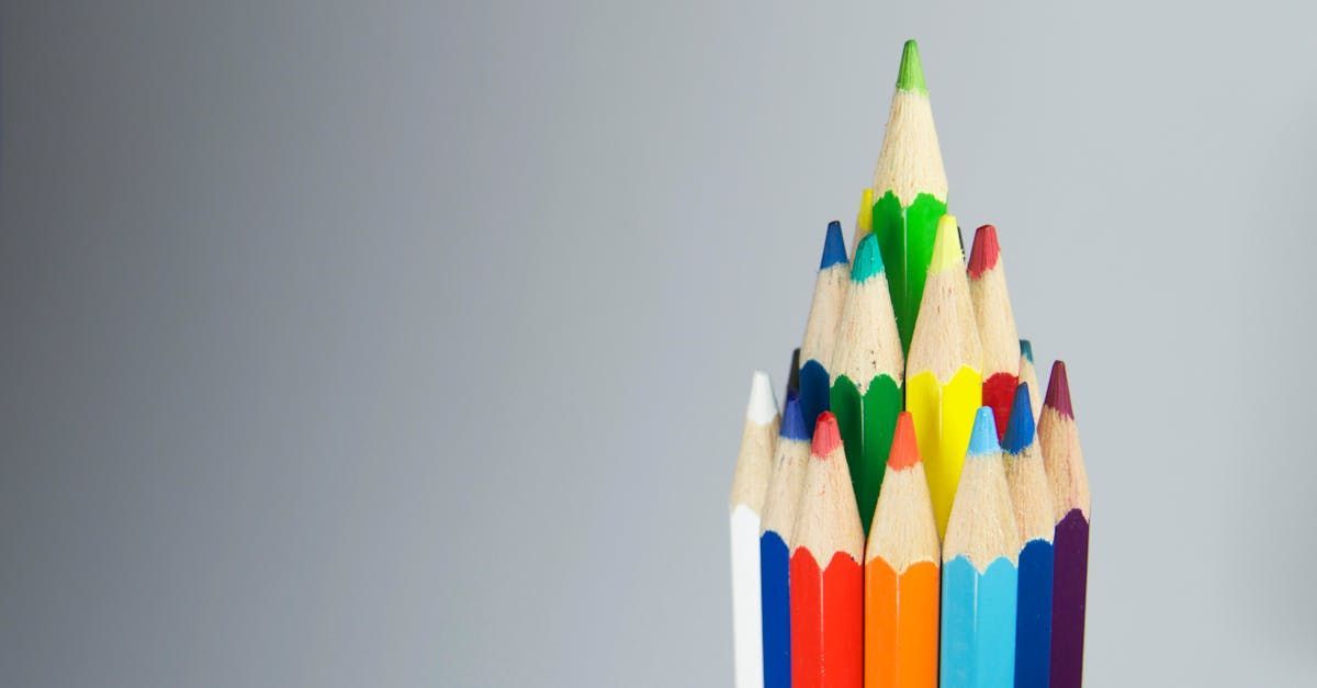 A bunch of colored pencils are stacked on top of each other on a table.