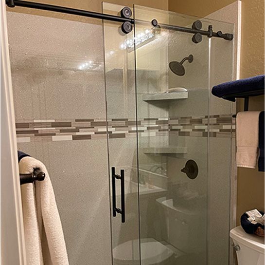 A bathroom with a sliding glass shower door and a toilet.