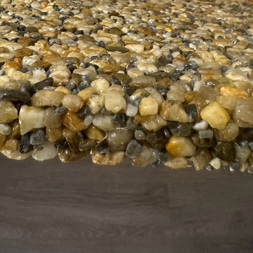 A close up of a circle of gravel on a white background.