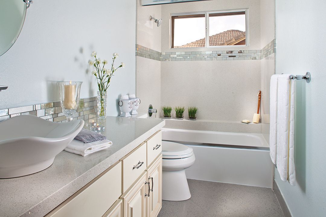 A bathroom with a sink , toilet , tub and window