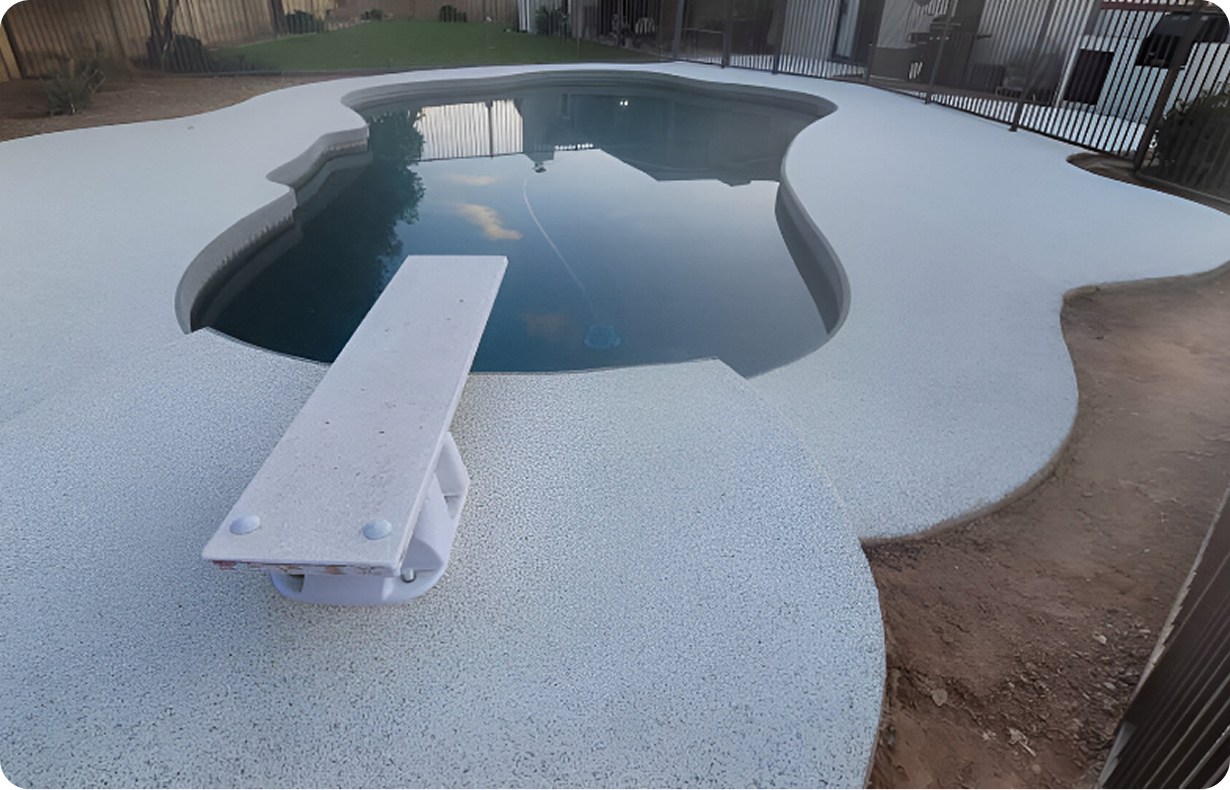 A large swimming pool is surrounded by a concrete patio.