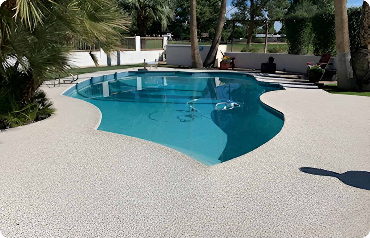 A large swimming pool is surrounded by a concrete patio.