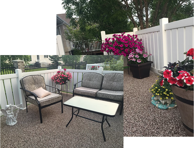 A patio with a couch , chair , table and flowers.