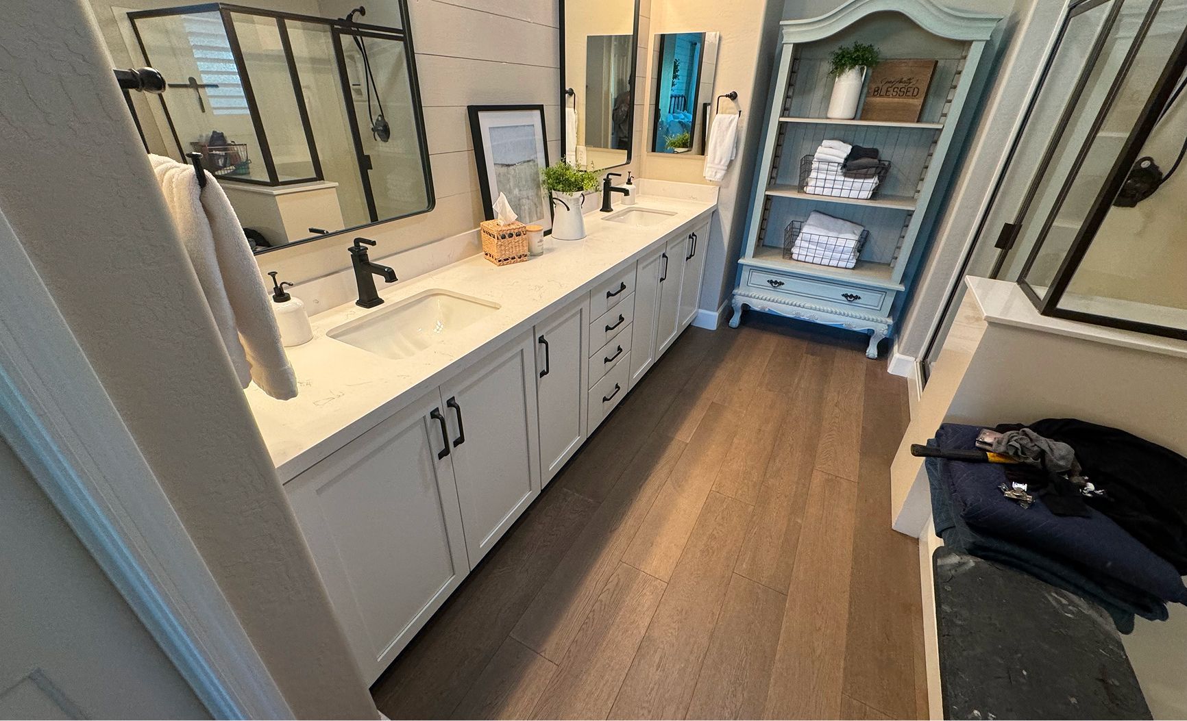 A bathroom with two sinks , a mirror and a shelf.