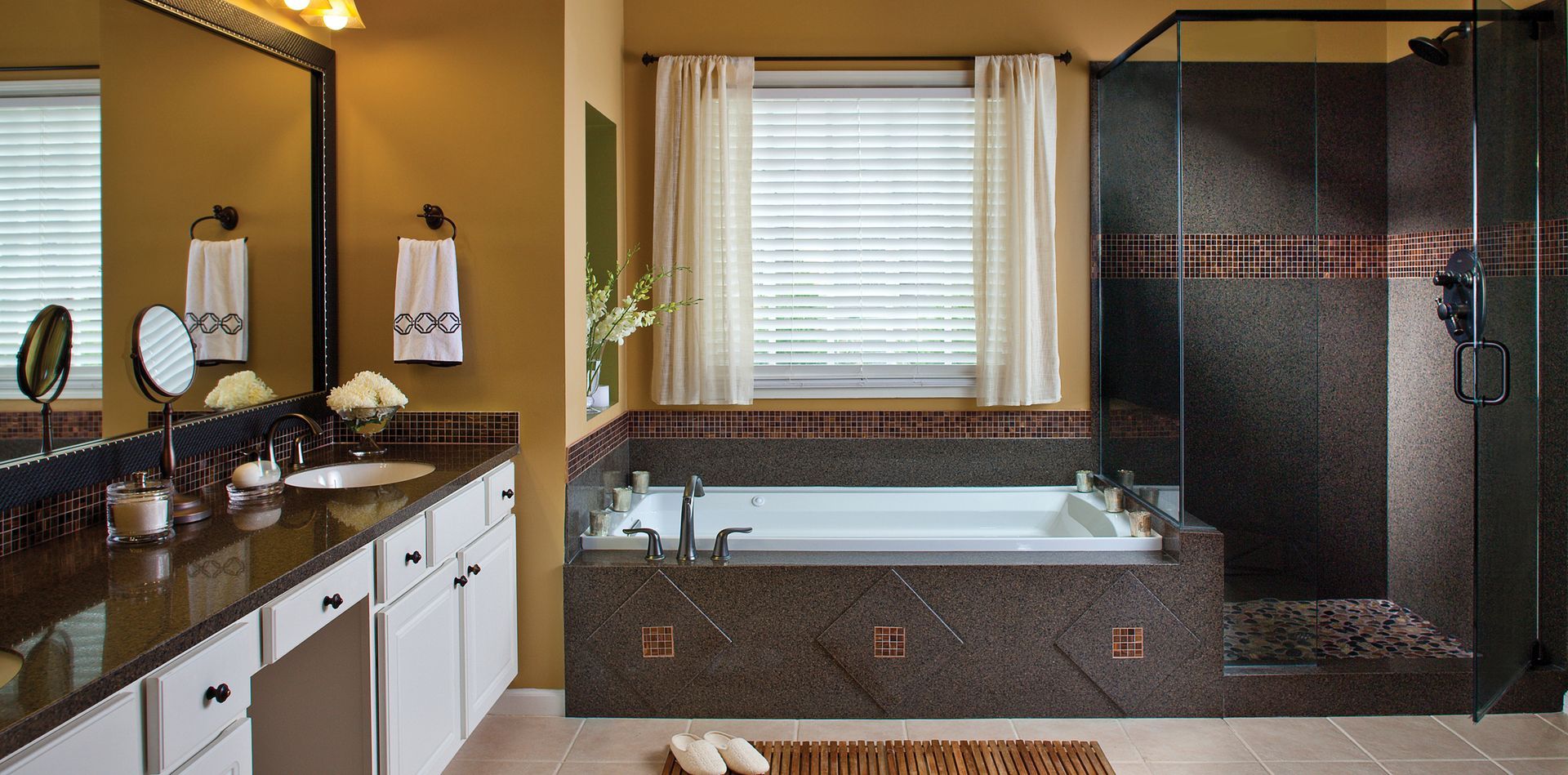 A bathroom with a tub , sink , mirror and walk in shower.