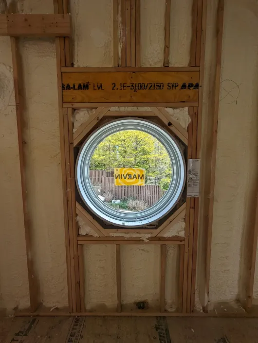 A round window is being installed in a wall.