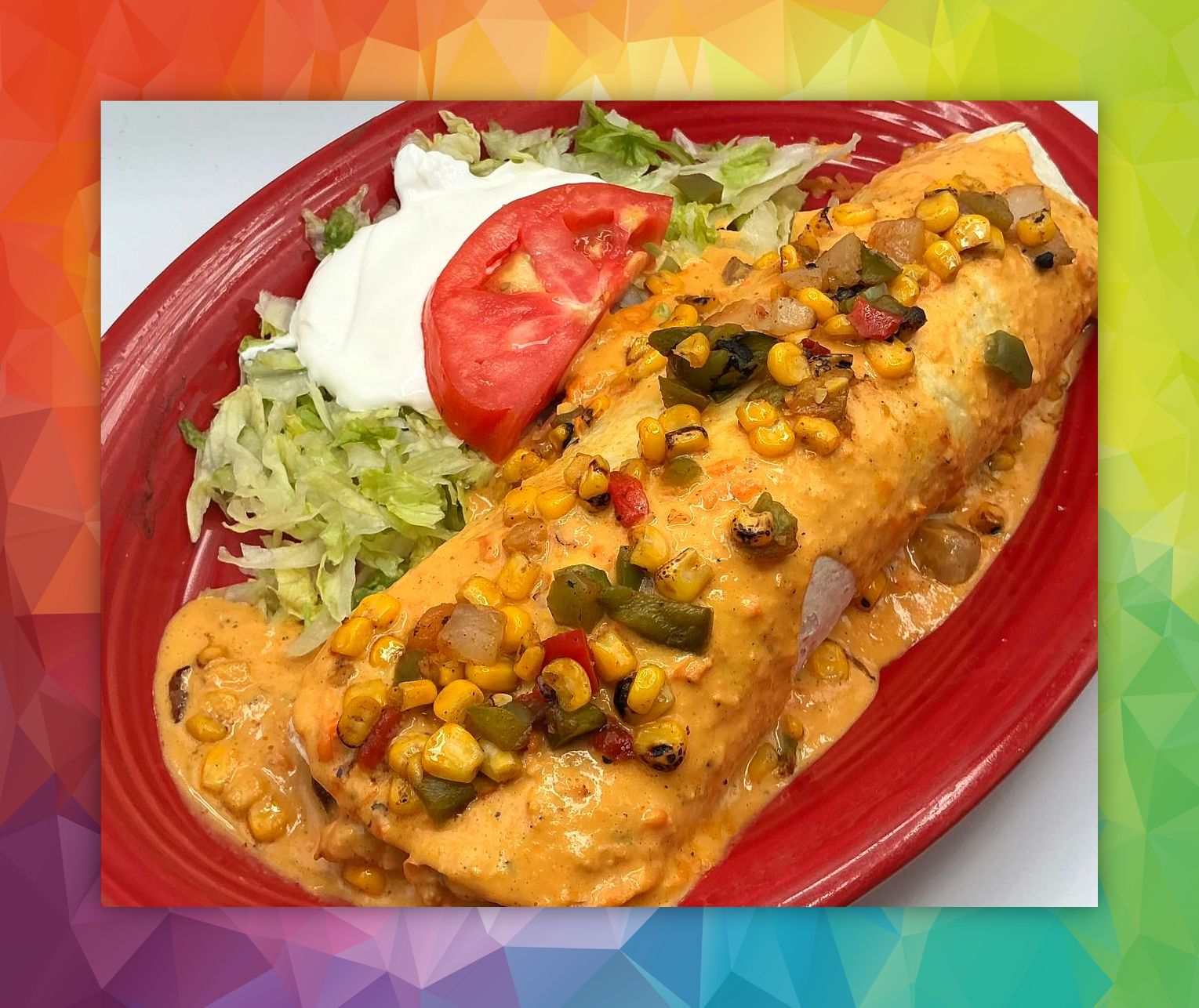 Enchilada on a red plate with sour cream, lettuce, and tomato, in a creamy sauce with corn and peppers.